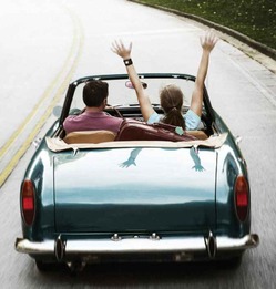 A man and a woman driving down a road