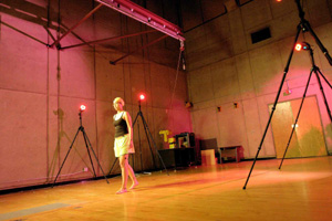 A woman walking in a gym, with cameras recording