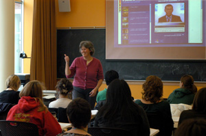 A professor teaching a class, using the internet