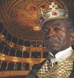 Man wearing crown and king's clothes in theater hall