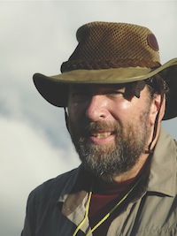 A man in outdoor clothing and hat