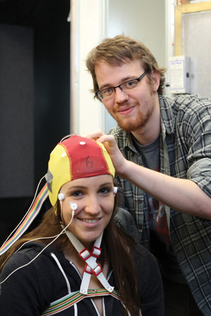 Young man placing brain cap on young woman