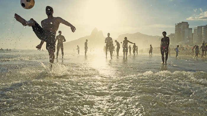 Image of people playing soccer on the beach